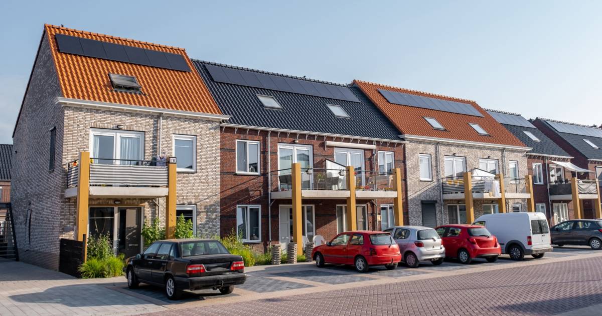 Nieuw gebouwde huizen met zonnepanelen op het dak met op de achtergrond een mooie blauwe lucht