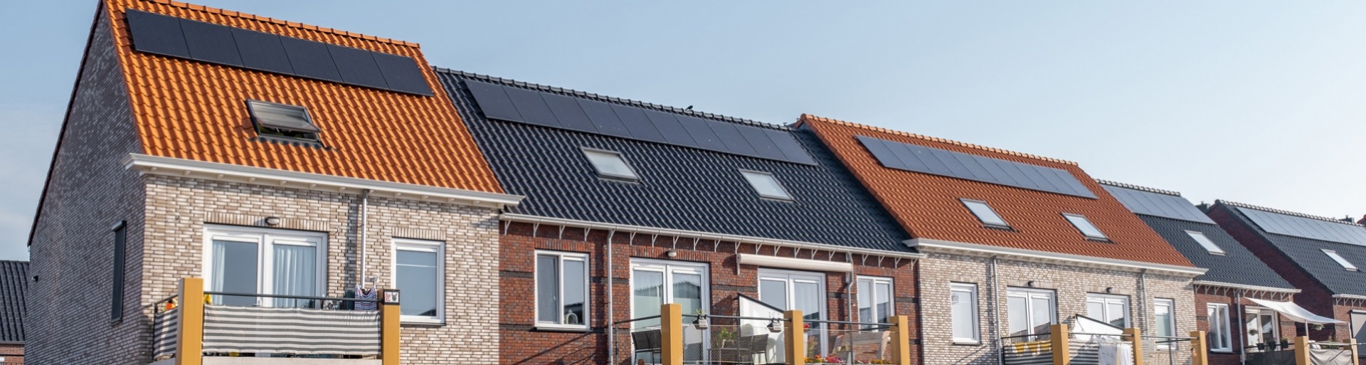 Nieuw gebouwde huizen met zonnepanelen op het dak met op de achtergrond een mooie blauwe lucht